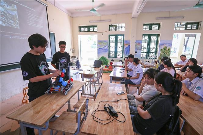 Các thành viên Đội GreenAms Robotics Team 24751A giới thiệu về mô hình Robot, cách tìm hiểu AI, lĩnh vực Robotics... cho học sinh trường Tiểu học &THCS Nhuận Trạch. (Ảnh: Trọng Đạt/TTXVN)